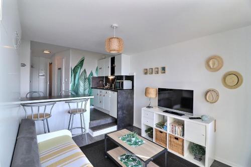 a living room with a couch and a kitchen at Cosy Deauville in Deauville