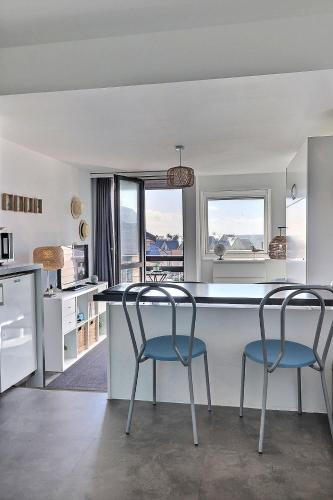 une cuisine avec deux chaises et un îlot de cuisine avec vue dans l'établissement Cosy Deauville Studio, à Deauville