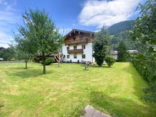 a house with a large yard with trees at Ferienhaus Wachterhof Aschau im Zillertal in Aschau