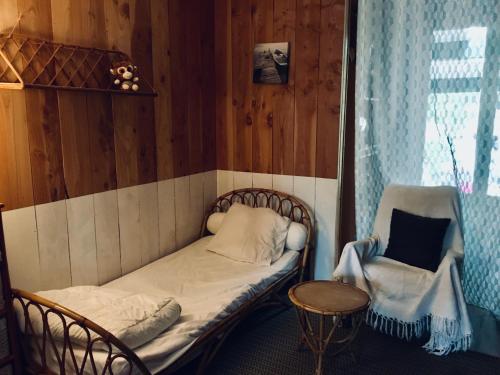een kleine kamer met een bed en een stoel bij guesthouse bassin d'arcachon à la hume in Gujan-Mestras