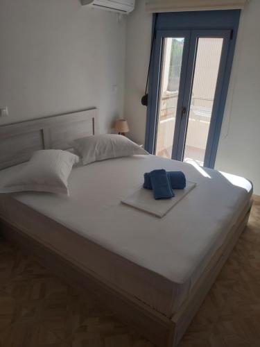 a large white bed with two blue towels on it at Maria's family house 1 in Elafonisos