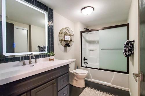 W łazience znajduje się umywalka, toaleta i lustro. w obiekcie Book Entire House, 3 Bedrooms in White Bear Lake w mieście Saint Paul