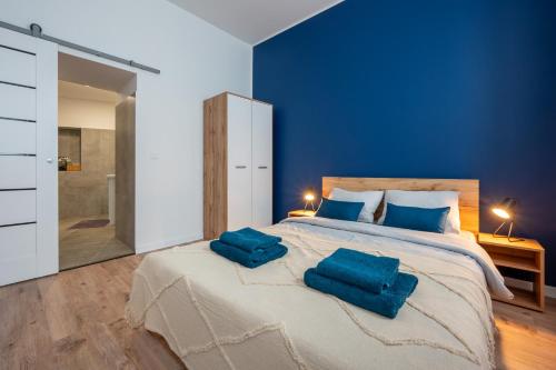 1 dormitorio con 1 cama grande y 2 almohadas azules en Atrament, en Przemyśl
