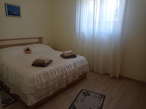een slaapkamer met een bed met twee handdoeken erop bij Apartman Mimi in Matulji