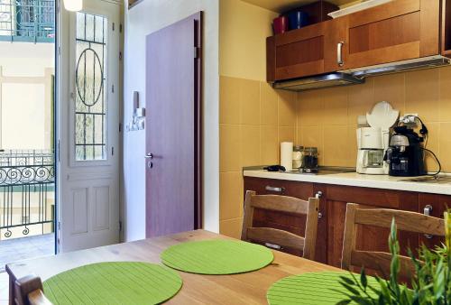 a kitchen with a wooden table and a dining room with at LEM Family Apartment in Budapest
