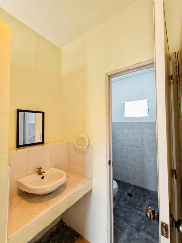 a bathroom with a sink and a toilet at Ander Divers Garden Resort in Anda