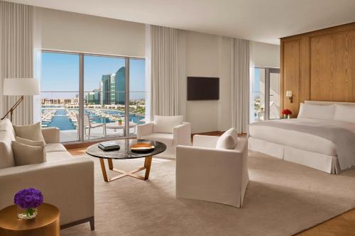 アブダビにあるThe Abu Dhabi EDITIONのベッド付きのホテルルームと景色を望むベッドルーム1室が備わります。
