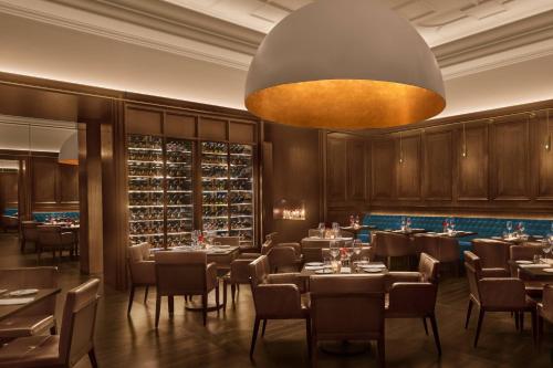a restaurant with tables and chairs and a chandelier at The Abu Dhabi EDITION in Abu Dhabi