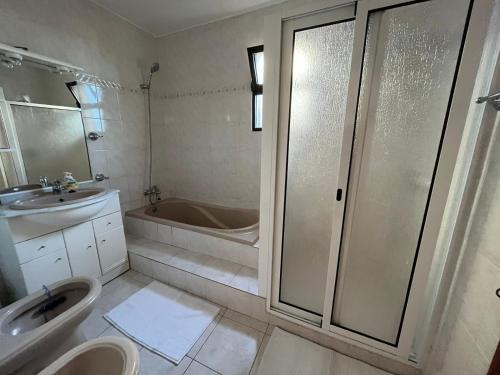 a bathroom with a tub and a sink and a toilet at Casa da Isilda ,three bedrooms in Estreito da Calheta