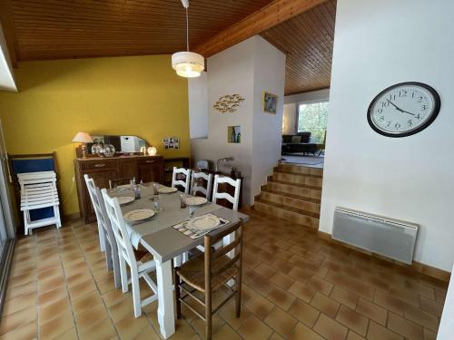 une salle à manger avec une table et une horloge au mur dans l'établissement Maison spacieuse, 600m plage, 6 couchages, parking gratuit, jardin, terrasse, WiFi optionnel - FR-1-224C-210, à Saint-Jean-de-Monts