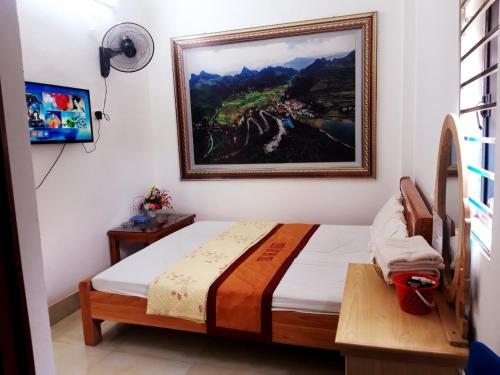 Schlafzimmer mit einem Bett mit Wandgemälde in der Unterkunft Yen Minh Hotel Thien An in Na Thôn