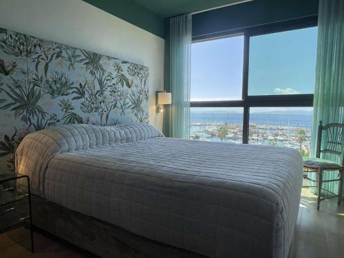 une chambre avec un lit et une grande fenêtre dans l'établissement Magnifique T3 Climatisé avec Vue sur Mer - FR-1-308-179, au Lavandou
