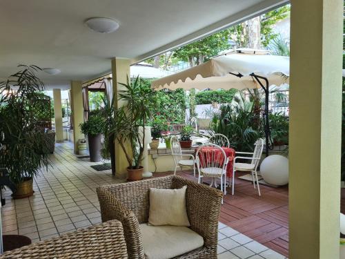 a patio with a table and chairs and an umbrella at Hotel Beppe in Rimini