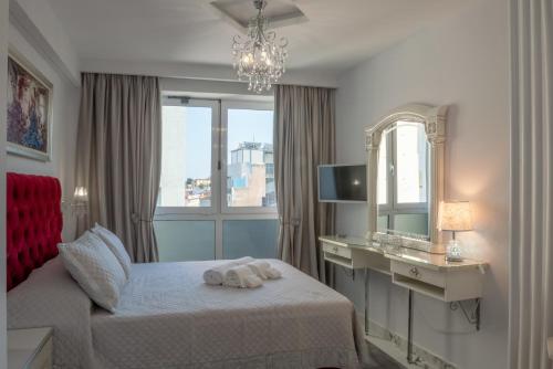 a bedroom with a bed with a mirror and a desk at Diana's Suite viewing the Acropolis in Athens