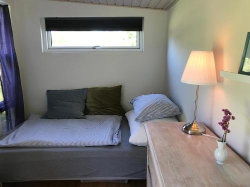 1 dormitorio con 1 cama y 1 mesa con lámpara en Cutest annex - close to Heatherhill and sea :-) en Vejby