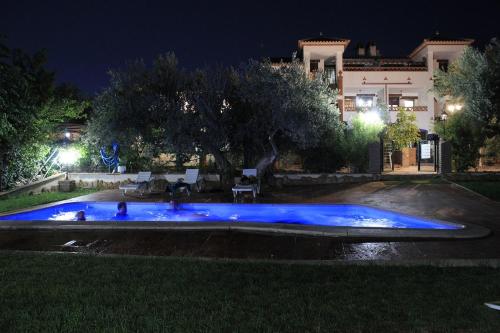 a pool with blue lights in a yard at night at Apartamentos La Granja in Hinojares
