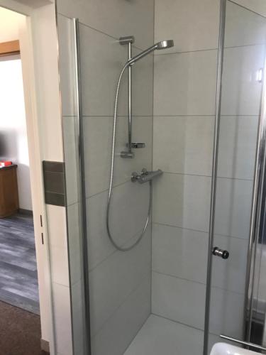 a shower stall with a glass shower door at Im alten Büro in Kelberg