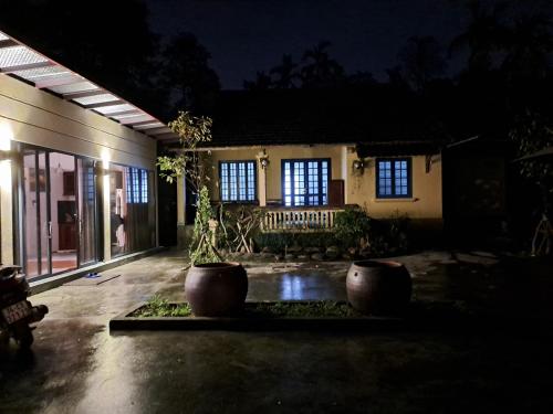 uma casa com dois grandes potes à sua frente à noite em Hương long secret gardern home and stay em Thôn An Vân Thượng
