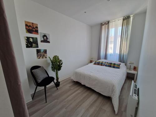 a white bedroom with a bed and a chair at Le ciel étoilé, Belfort ville in Belfort