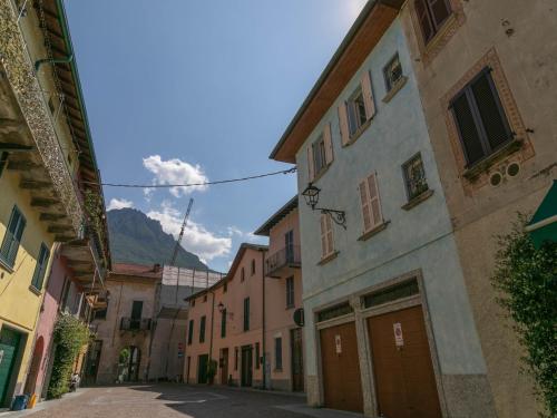 um beco com edifícios e uma montanha ao fundo em Mamma Ciccia Holiday Home - Casa Azzurra em Mandello del Lario