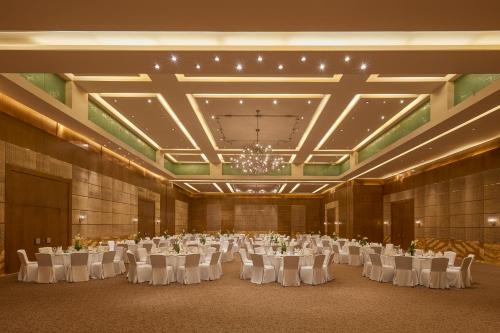 a large banquet hall with white tables and chairs at Marina Hotel in Kuwait