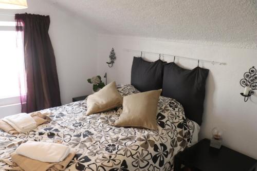 un letto con cuscini sopra in una camera da letto di MappaMundo a Ribamar