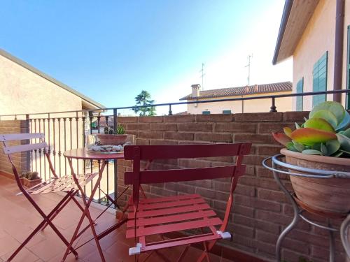 een terras met twee stoelen en een tafel op een balkon bij aldueci in Ravenna