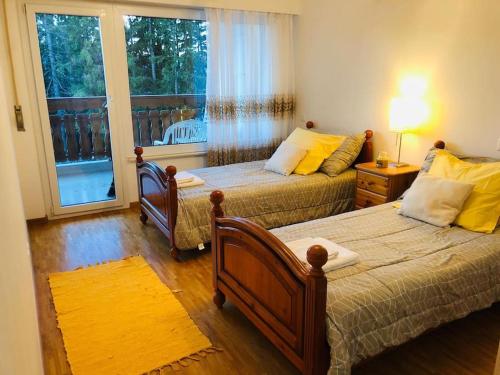 a bedroom with two beds and a window at Appartement traversant secteur Violettes in Crans-Montana