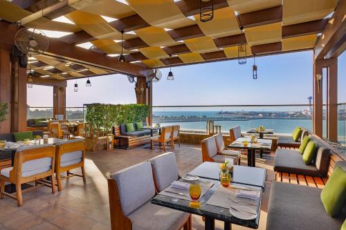a restaurant with tables and chairs and a view of the water at The St. Regis Abu Dhabi in Abu Dhabi