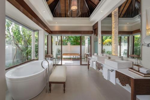 een badkamer met 2 wastafels en een groot bad bij The Laguna, A Luxury Collection Resort & Spa, Nusa Dua, Bali in Nusa Dua