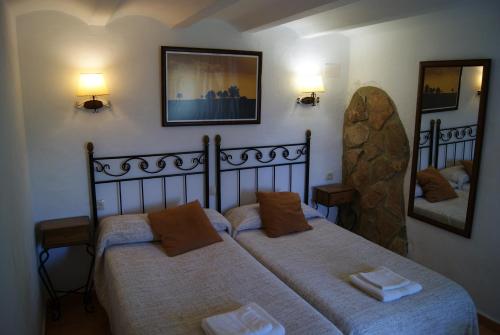 a bedroom with two beds and a mirror at Casas Rurales Los Cortijos in Alcaraz