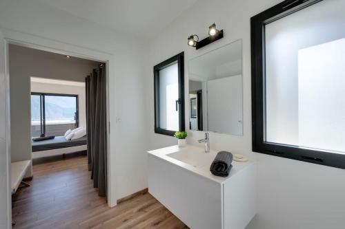 ein Badezimmer mit einem weißen Waschbecken und 2 Spiegeln in der Unterkunft Villa Bamboo in Lathuile