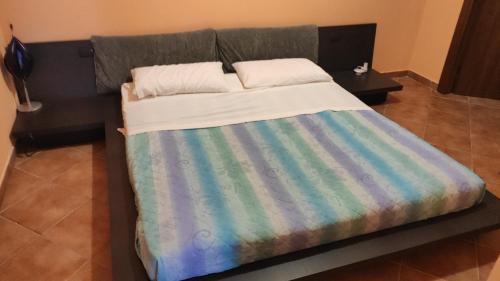 ein Bett mit einer bunten Decke darüber in der Unterkunft Casa Maremonti vicino Cefalu in Campofelice di Roccella