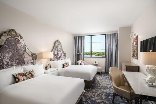 a hotel room with two beds and a desk at JW Marriott Savannah Plant Riverside District in Savannah