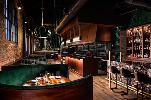 a restaurant with a green bar with wine glasses at JW Marriott Savannah Plant Riverside District in Savannah