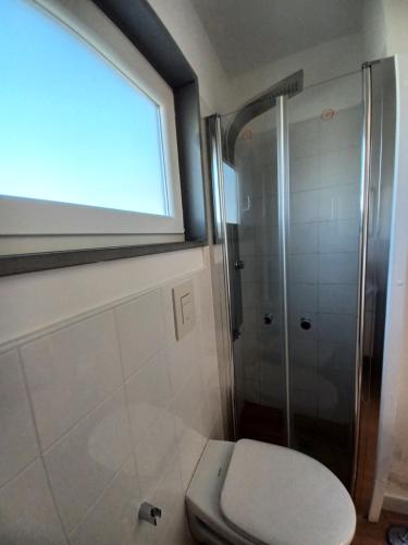 a bathroom with a toilet and a shower with a window at Eolia free parking in Bari
