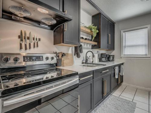 a kitchen with stainless steel appliances and a sink at The Noir in Oklahoma City