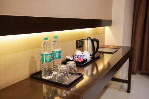 two bottles of water and glasses on a table at Hotel Atithi, Aurangabad in Aurangabad