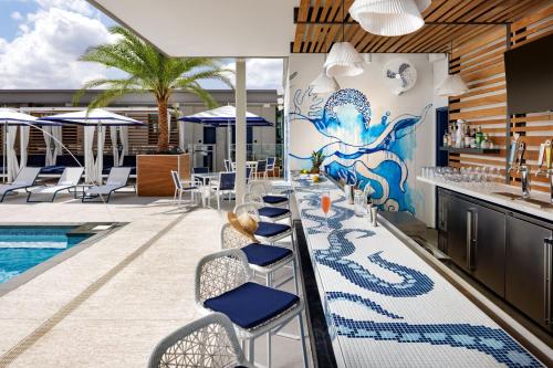 a restaurant with a bar and a pool at JW Marriott Savannah Plant Riverside District in Savannah