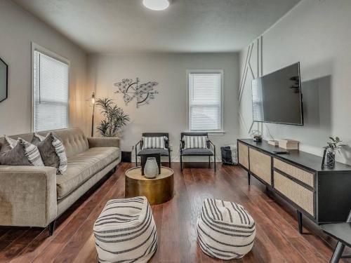 a living room with a couch and a flat screen tv at The Noir in Oklahoma City