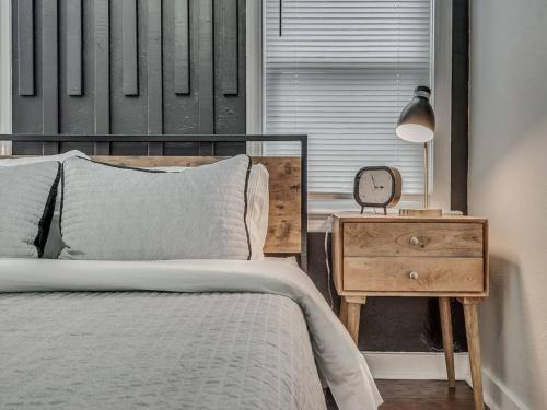 a bedroom with a bed and a table with a clock at The Noir in Oklahoma City