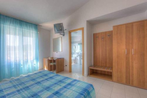 een slaapkamer met een bed, houten kasten en een televisie bij Hotel Mizar in Chianciano Terme