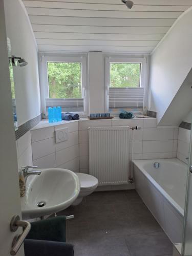 a bathroom with a sink and a toilet and a tub at An den Eichen in Neustadt am Rübenberge