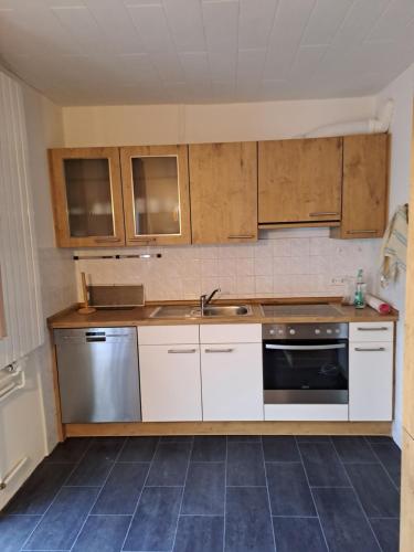 a kitchen with white cabinets and a sink and a stove at An den Eichen in Neustadt am Rübenberge