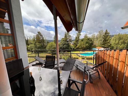 patio con tavolo e sedie su una terrazza di Lipno Holiday Penthouse a Lipno nad Vltavou
