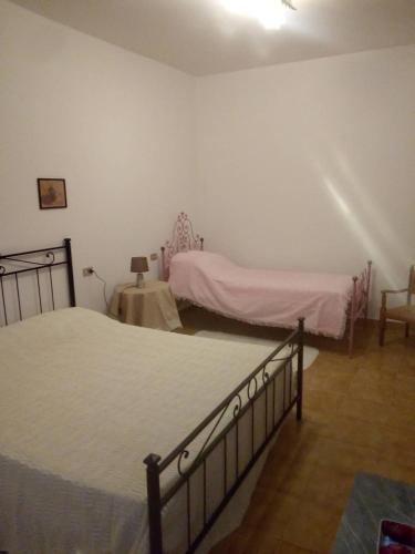 a bedroom with two beds and a table with a lamp at Casa Carducci Affittacamere in Monteleto