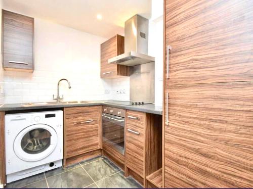 a kitchen with a washing machine and a washer at Twickenham studio private apartment in Twickenham