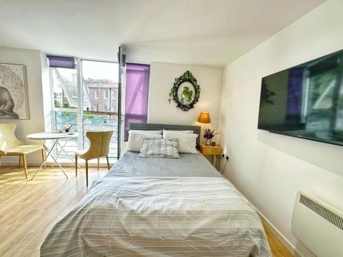 1 dormitorio con 1 cama y 1 mesa con sillas en Twickenham studio private apartment, en Twickenham