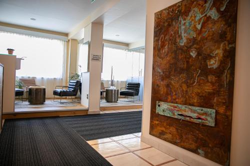 a lobby with a large painting on the wall at Das Reinisch Hotel - near Vienna Airport in Schwechat