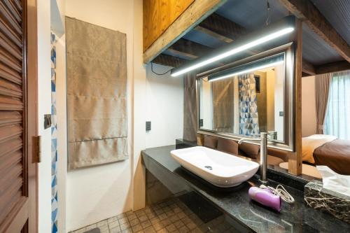 a bathroom with a sink and a mirror at Tepbunthom Hostel in Bangkok